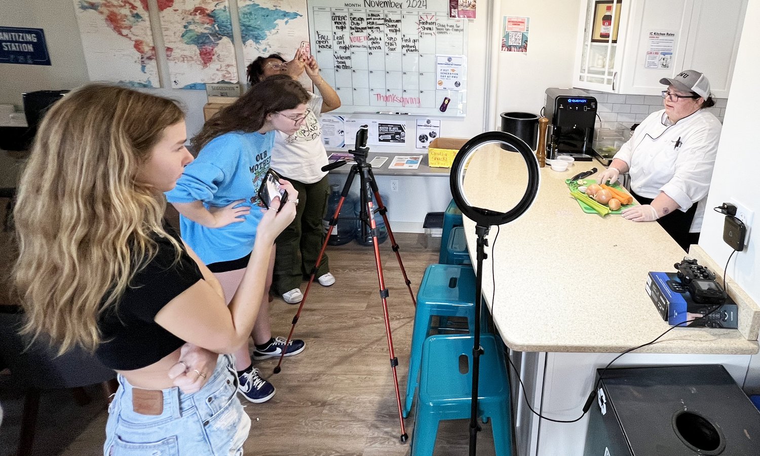 Hope Pod team members film a sous chef in the Intercultural Center's kitchen.
