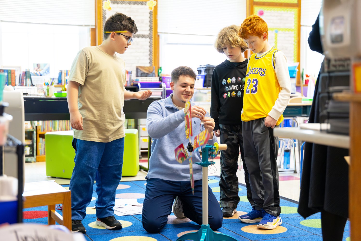 Fourth graders watch as an RWU student connects an ammeter to a wind turbine.