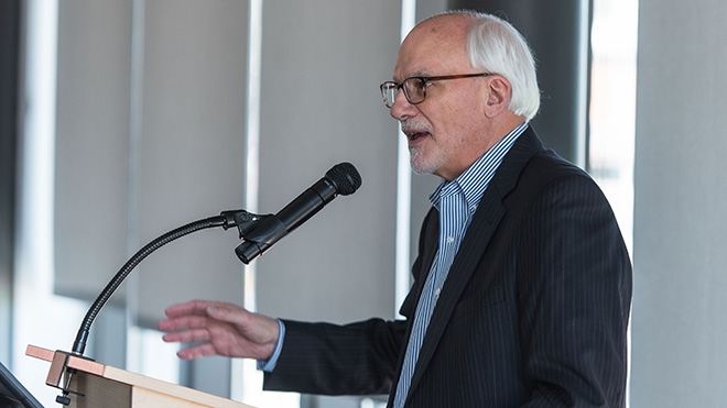 Richard Godfrey speaking into a microphone at a podium