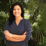 Morgan Branco stands in front of palm leaves