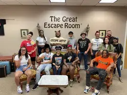 students taking a group picture at the lobby of the an escape room
