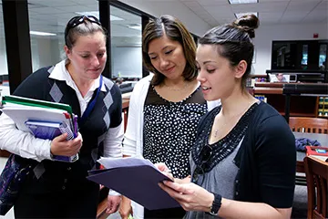 Students in a library seeing a book