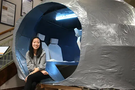 Student Hien Ngo sits inside her model Mars rover.