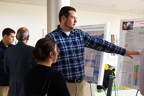 Student discusses his research at the Student Academic Showcase and Honors.