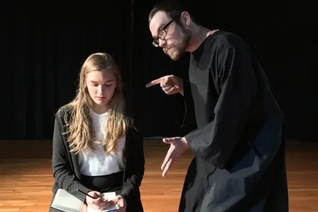 Two actors performa scene on stage.