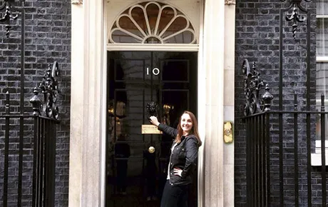 A student stands in front of the headquarters of the British government.