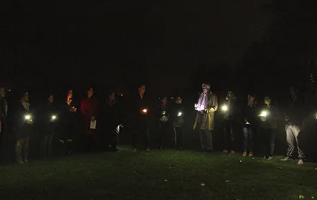Students, faculty and staff gather to hold a candlelight vigil on campus.