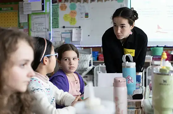 Student works with elementary students at a school