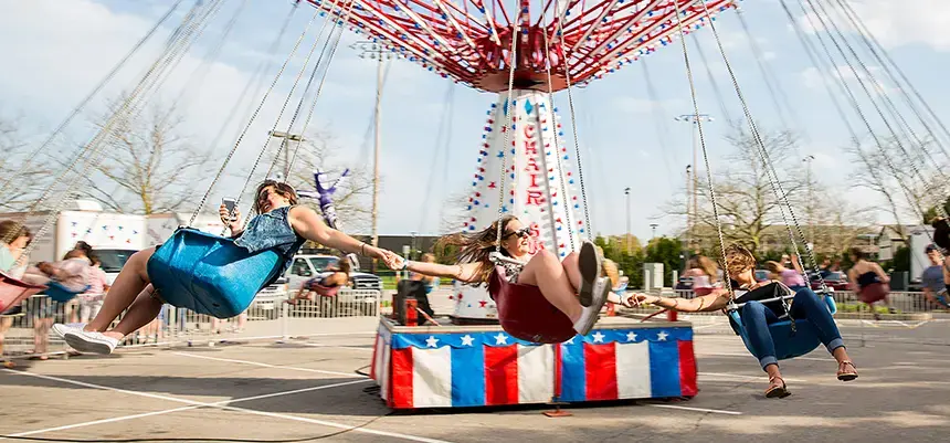 Students take an amusement park ride at Spring Carnival.