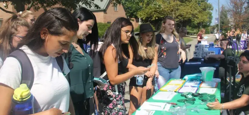 Students learning about clubs and orgs at the involvement fair