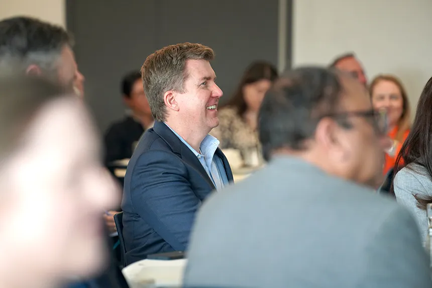 Real Estate Symposium attendees laugh along with panelists.