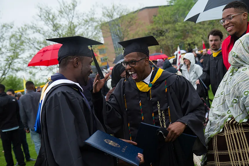 two students celebrating after graduation ceremony