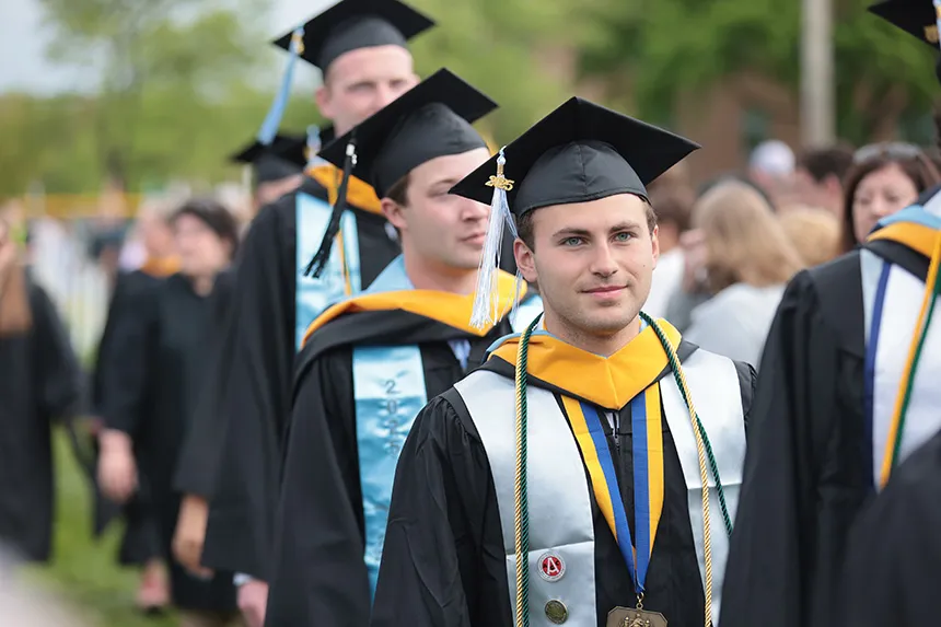 An RWU graduate walks in the procession.