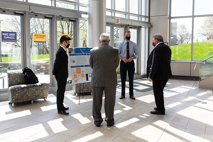 Student shows poster to President